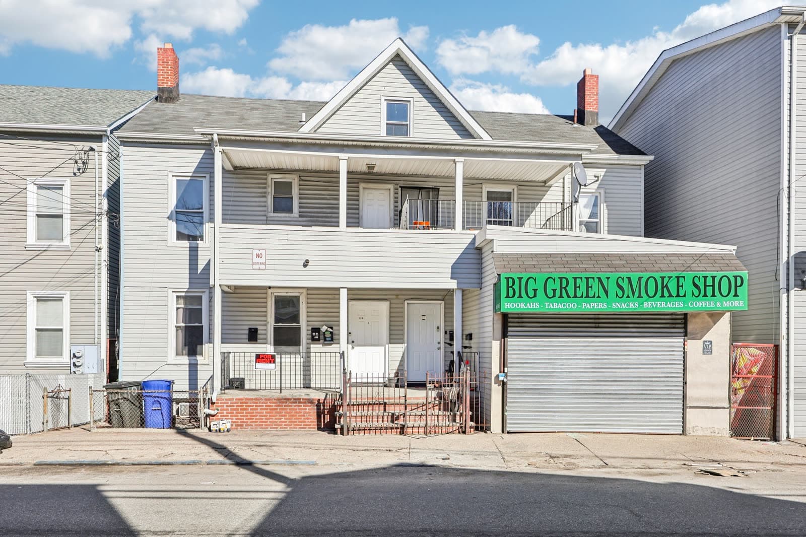 Front of the building with a two-story covered porch and a ground-floor storefront