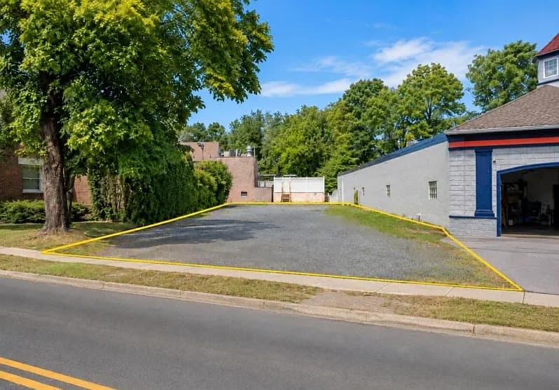 Level gravel lot outlined in yellow along South Avenue, next to a one-story commercial building
